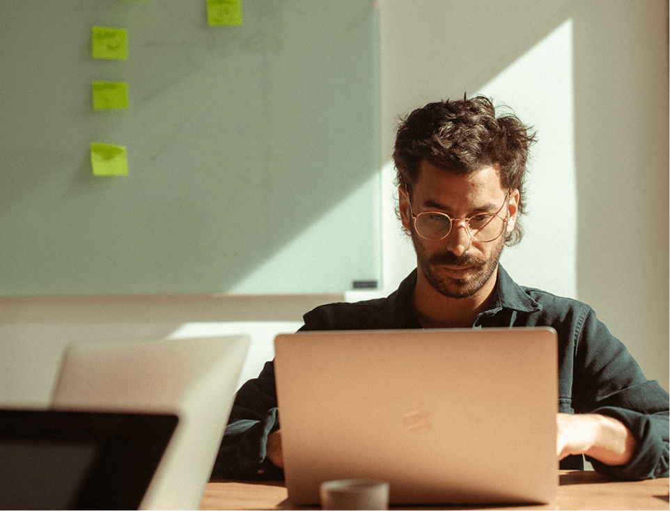 Person sitting in a desk with a laptop 